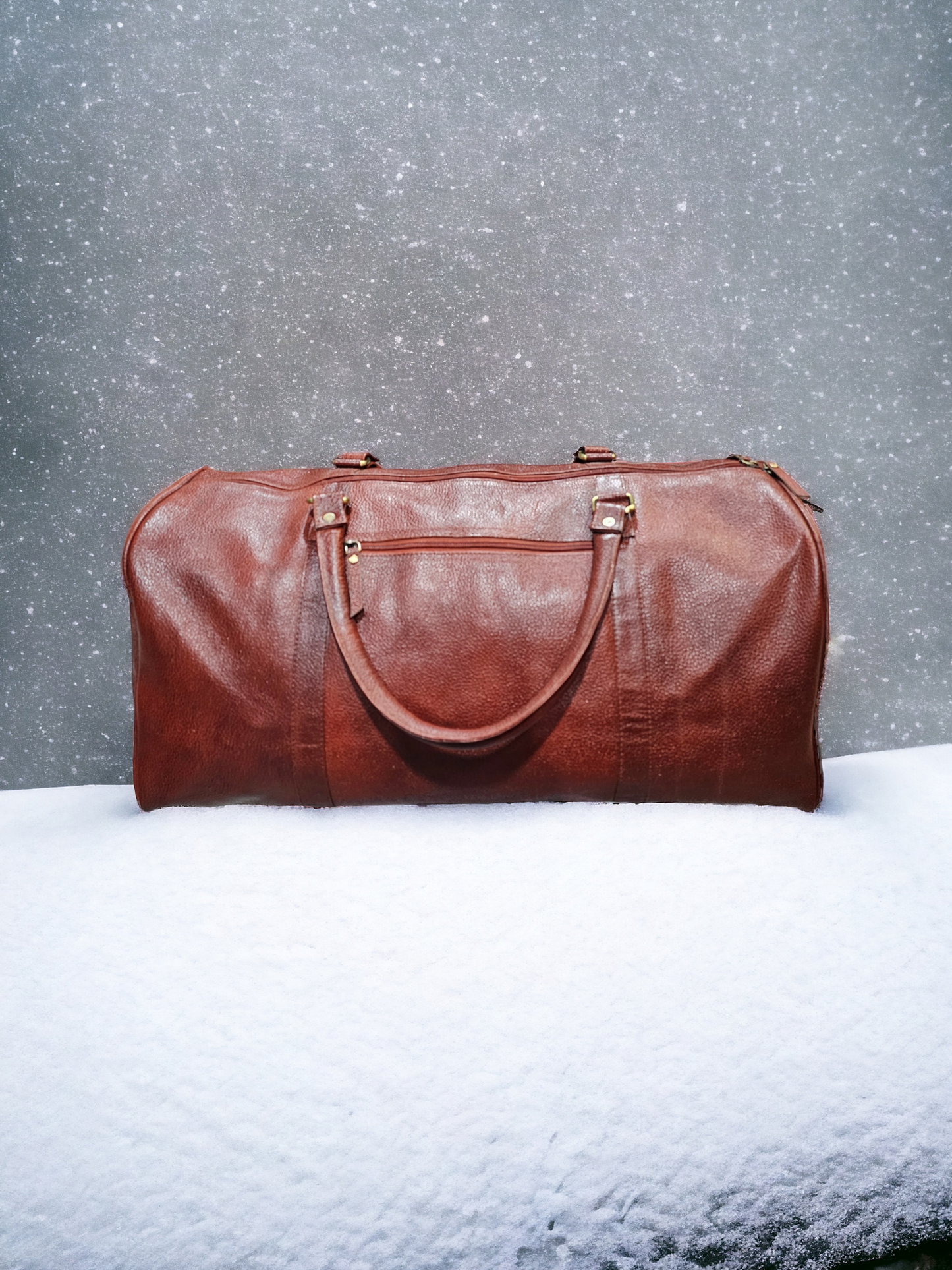 Large brown leather duffel bag with adjustable shoulder strap, sturdy handles, and spacious compartments. Durable and stylish, perfect for extended trips.