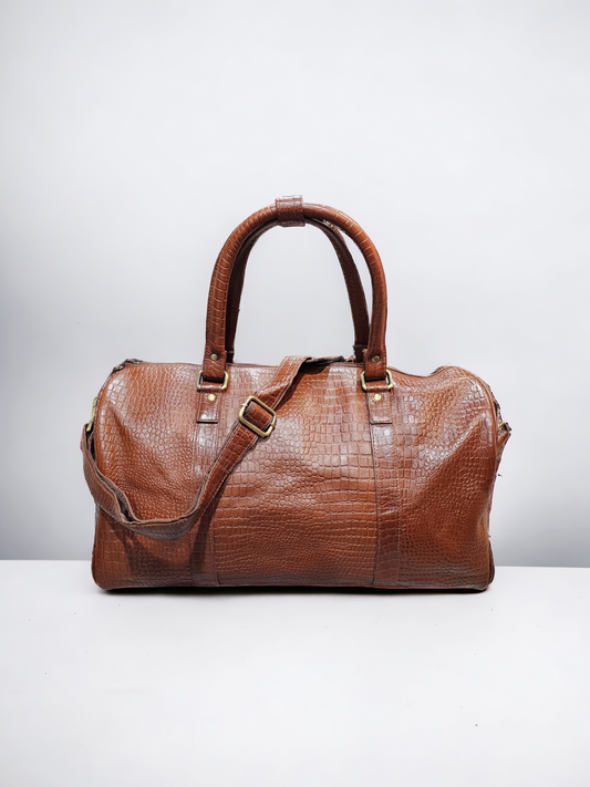 Small brown leather duffel bag with croco pattern, adjustable shoulder strap, and multiple compartments. Durable and stylish, perfect for short trips and everyday use.
