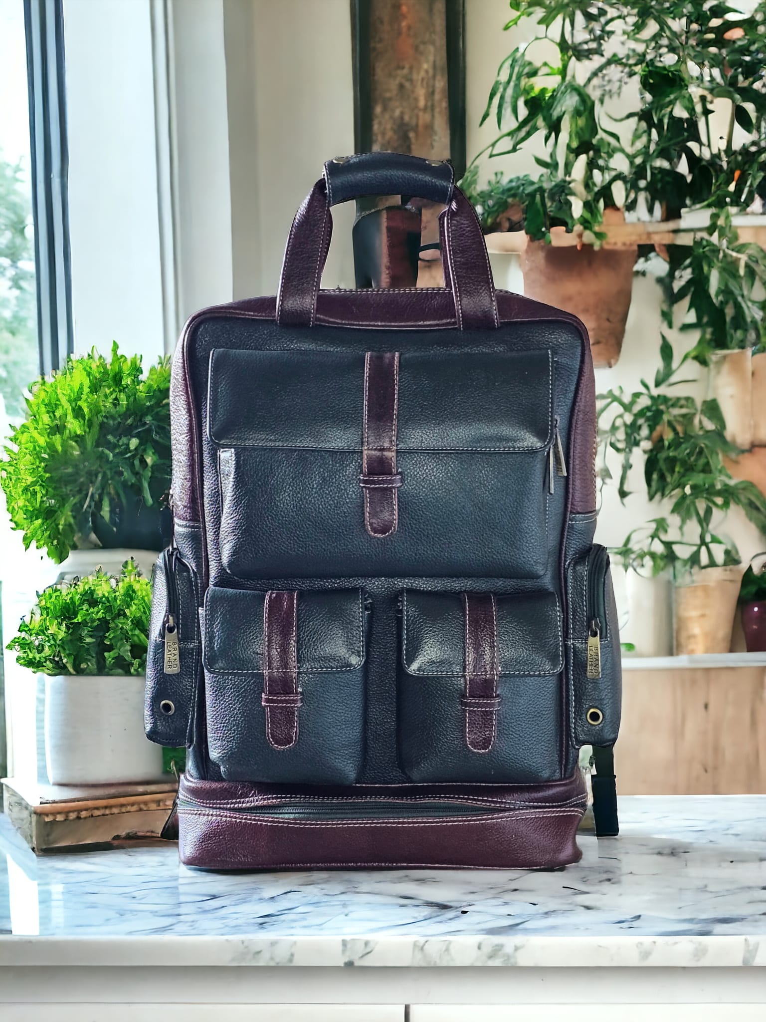 Green and brown leather unisex backpack with multiple compartments, umbrella holder, and adjustable shoulder straps. Spacious, durable, and stylish for work, school, or travel.