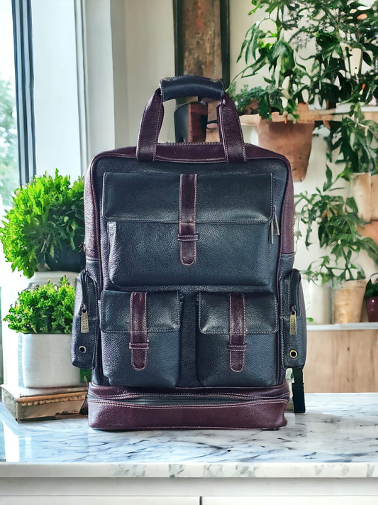 Green and brown leather unisex backpack with multiple compartments, umbrella holder, and adjustable shoulder straps. Spacious, durable, and stylish for work, school, or travel.