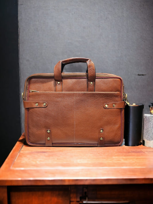 Brown leather 15-inch laptop bag with padded compartments, front and rear zippered pockets, and adjustable shoulder strap. Stylish, durable, and perfect for professionals and students.
